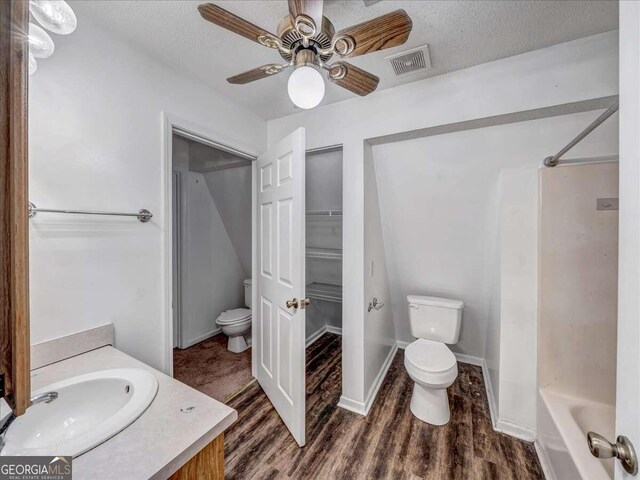 full bathroom with vanity, hardwood / wood-style flooring, toilet, and shower / bathtub combination