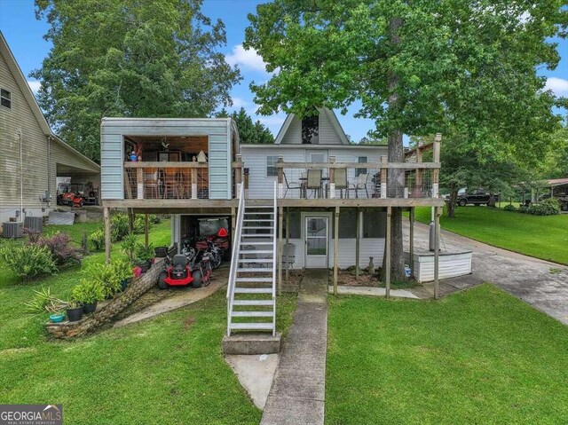 back of house with central AC, a wooden deck, and a yard