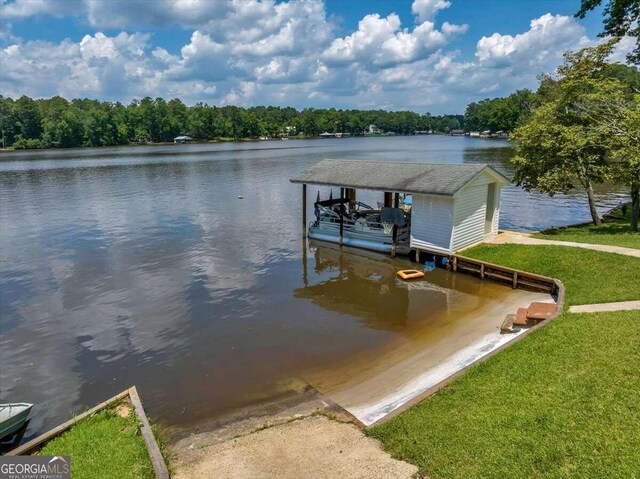 view of dock with a lawn and a water view