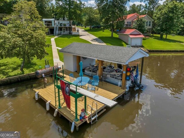 dock area with a lawn and a water view