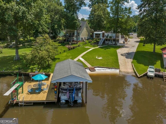 view of dock with a water view and a yard