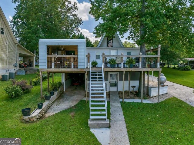 back of property featuring central AC unit, a lawn, and a wooden deck