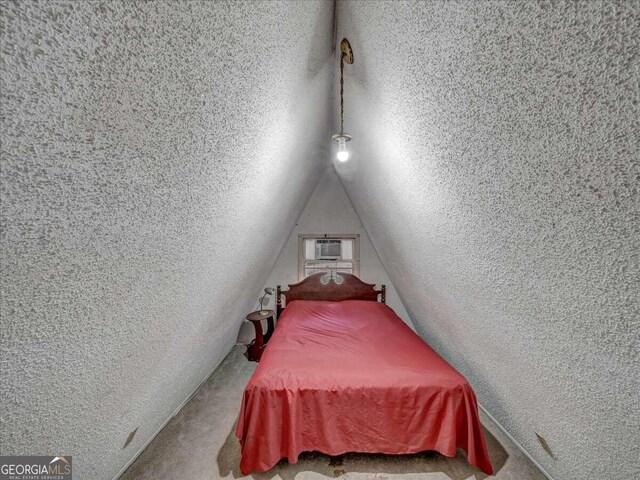 bedroom with carpet, a textured ceiling, and lofted ceiling