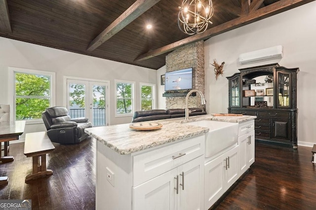 kitchen featuring wooden ceiling, lofted ceiling with beams, dark hardwood / wood-style floors, and a center island with sink