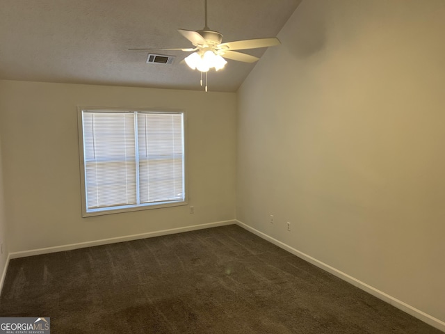 unfurnished room featuring ceiling fan, vaulted ceiling, and dark colored carpet