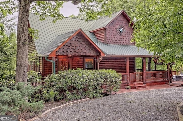 log-style house with a wooden deck