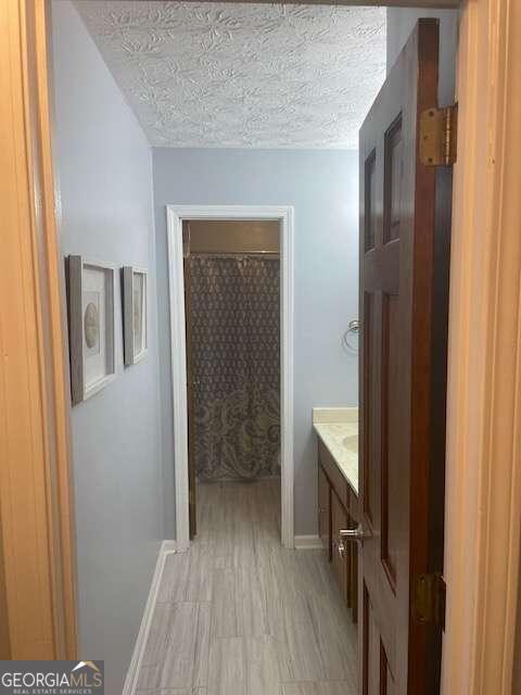 bathroom with a textured ceiling and vanity