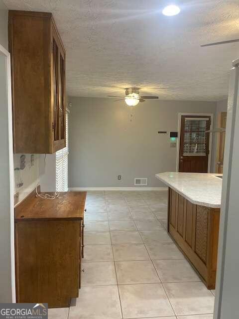 kitchen with ceiling fan and light tile floors