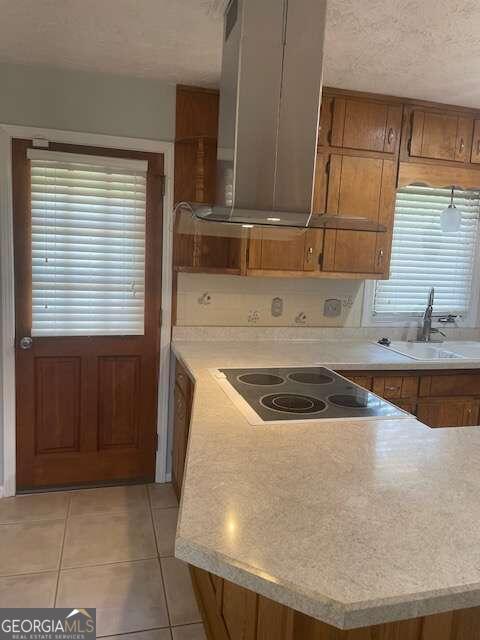 kitchen with black electric cooktop, sink, plenty of natural light, and range hood