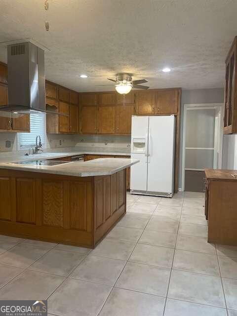 kitchen with light tile floors, fume extractor, ceiling fan, and white refrigerator with ice dispenser