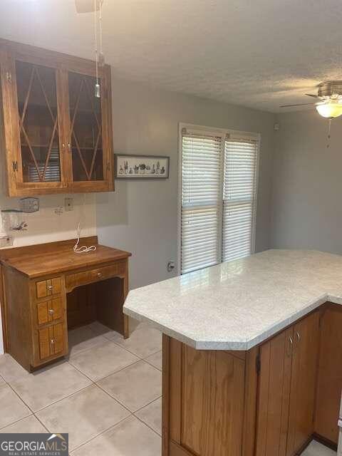 kitchen featuring ceiling fan and light tile floors