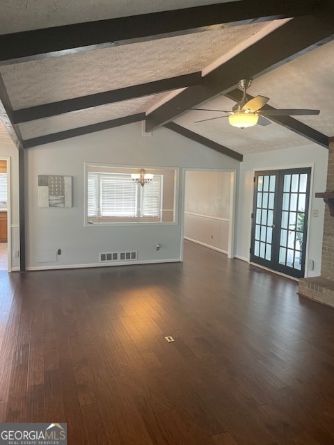 unfurnished living room with french doors, brick wall, dark wood-type flooring, vaulted ceiling with beams, and ceiling fan with notable chandelier