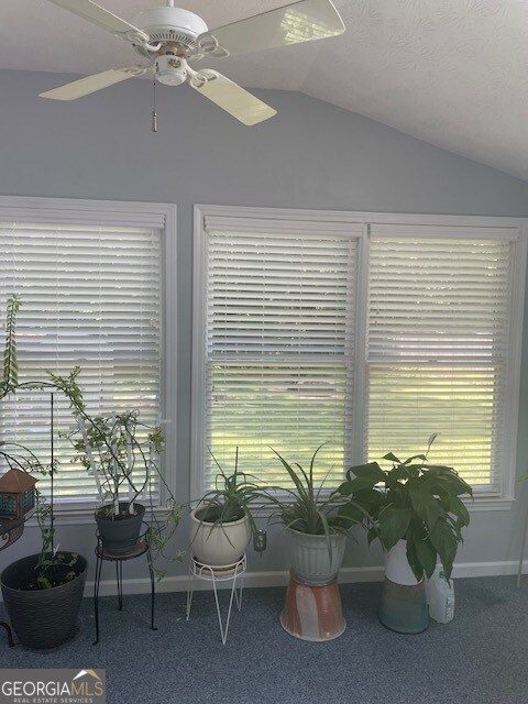 unfurnished sunroom featuring ceiling fan and lofted ceiling