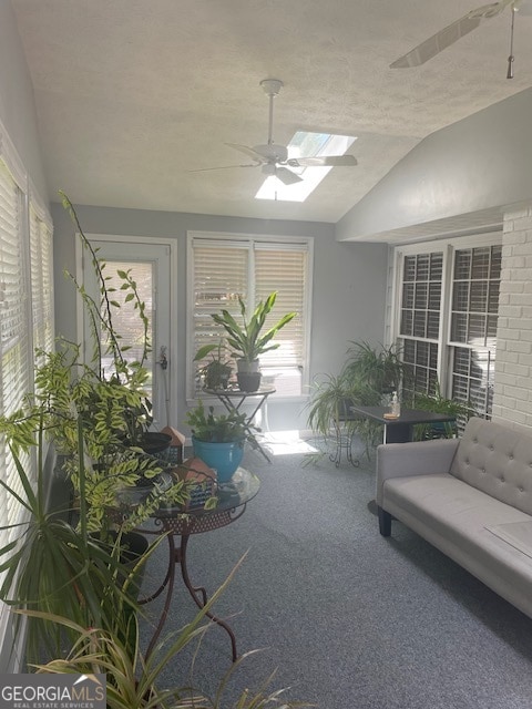 sunroom featuring ceiling fan, a wealth of natural light, and lofted ceiling with skylight