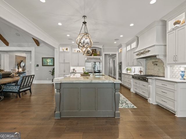 kitchen with white cabinets, backsplash, and custom exhaust hood