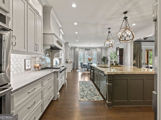 kitchen with custom range hood, dark hardwood / wood-style flooring, decorative light fixtures, backsplash, and sink