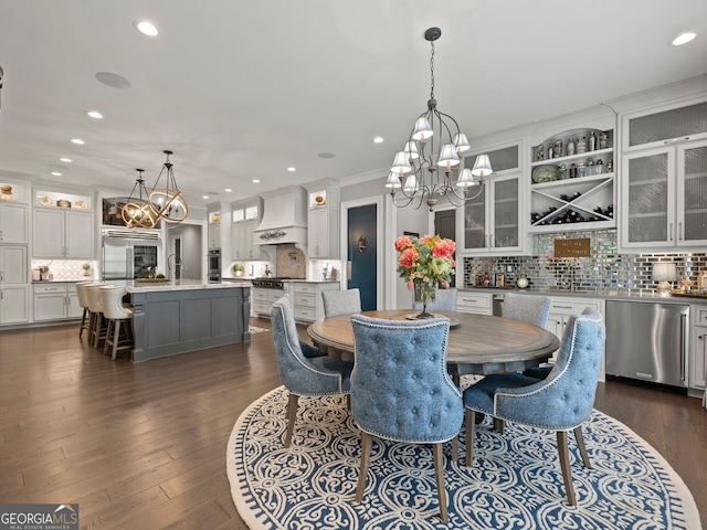 dining area featuring dark hardwood / wood-style floors, a notable chandelier, ornamental molding, and sink