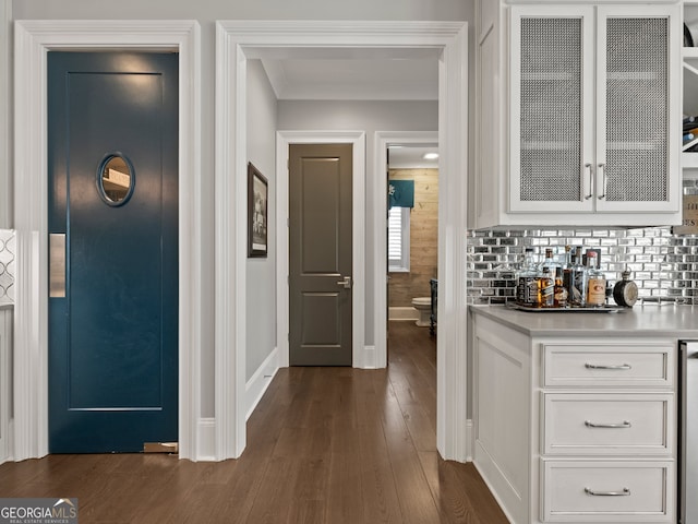 bar featuring dark hardwood / wood-style flooring, white cabinets, and tasteful backsplash