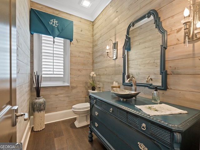 bathroom featuring hardwood / wood-style floors, wood walls, toilet, and large vanity