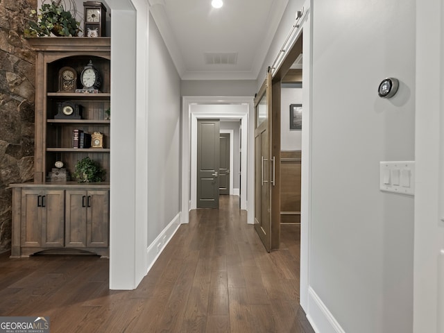 hall featuring dark hardwood / wood-style flooring, a barn door, and crown molding