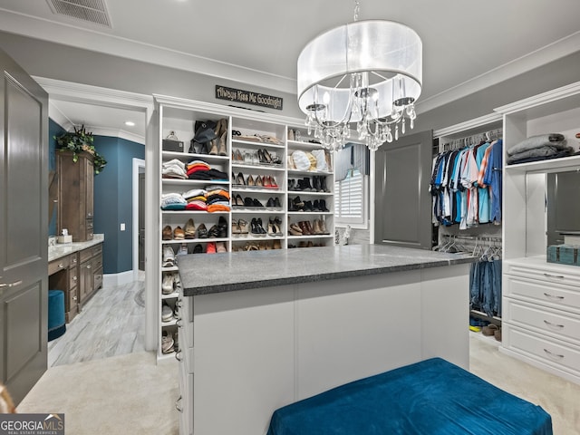 walk in closet featuring a notable chandelier and light wood-type flooring