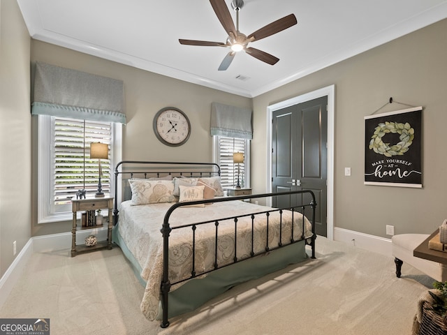 carpeted bedroom featuring ceiling fan and crown molding