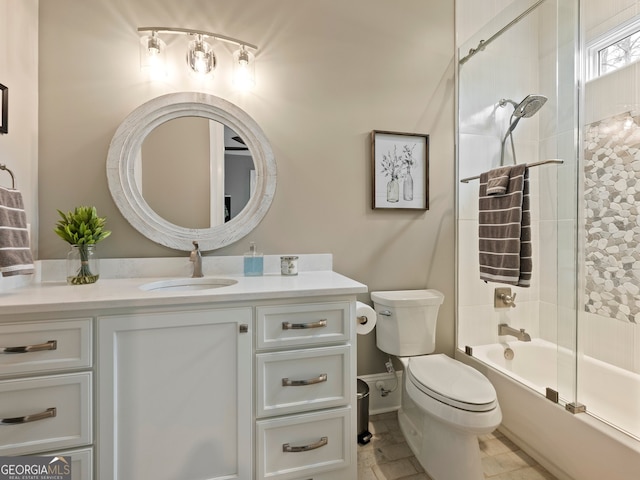 full bathroom with tile floors, tiled shower / bath, vanity, and toilet