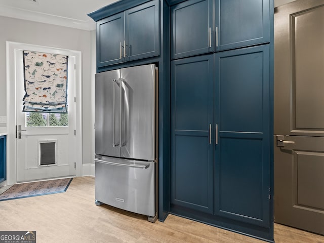 kitchen featuring stainless steel refrigerator, ornamental molding, blue cabinets, and light wood-type flooring