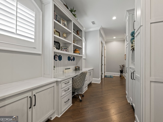 office featuring dark hardwood / wood-style floors, built in desk, and crown molding