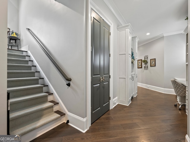 stairway featuring crown molding and dark wood-type flooring