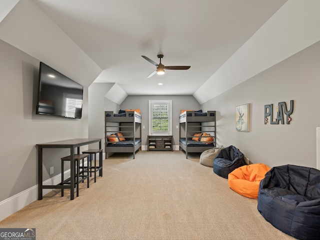 interior space with vaulted ceiling, light carpet, and ceiling fan