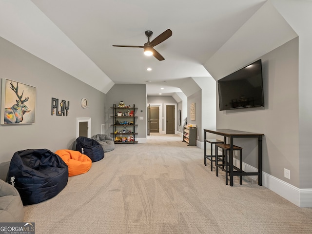 sitting room with ceiling fan, lofted ceiling, and carpet flooring