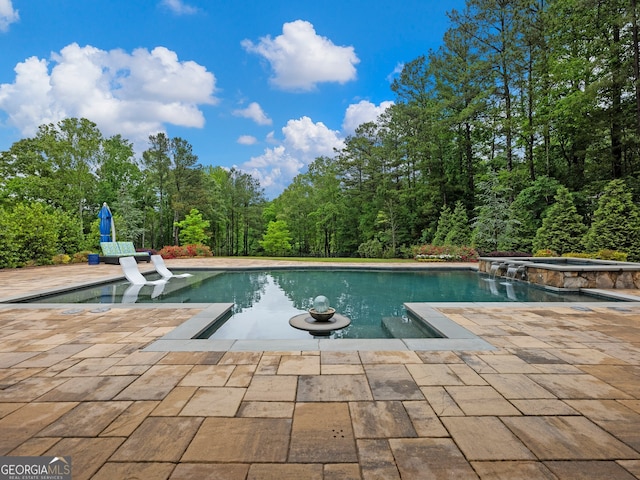 view of pool featuring a patio area and an in ground hot tub