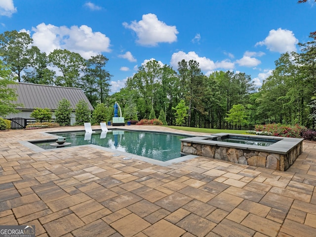 view of swimming pool featuring an in ground hot tub and a patio