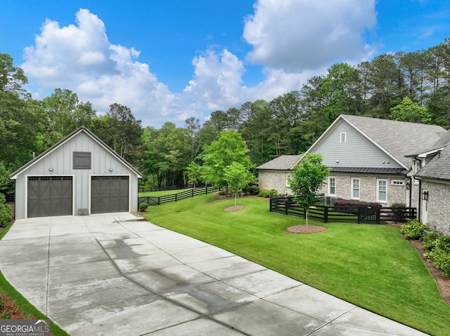 view of front of property featuring a garage, a front lawn, and an outdoor structure