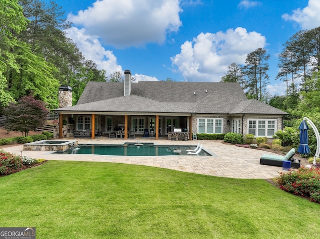 exterior space with a patio, an in ground hot tub, and a lawn