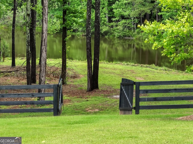 view of gate featuring a water view and a yard