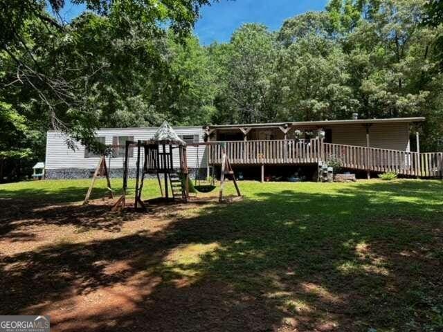 back of house featuring a deck and a yard