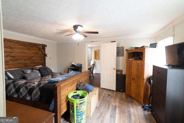 bedroom with a textured ceiling, dark wood-type flooring, ornamental molding, and ceiling fan