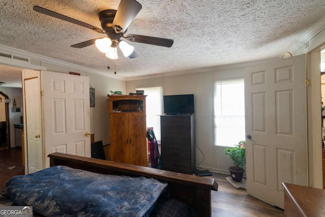 bedroom with ceiling fan, multiple windows, a textured ceiling, and wood-type flooring