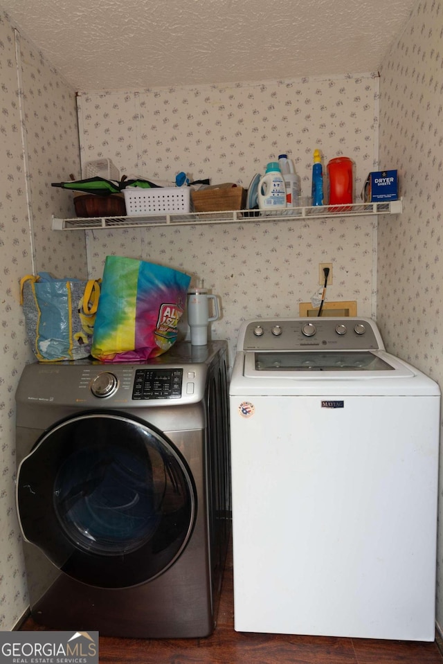 clothes washing area with washer and clothes dryer, a textured ceiling, and hookup for a washing machine