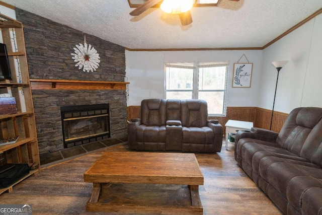 living room featuring a textured ceiling, a fireplace, wood-type flooring, and ceiling fan