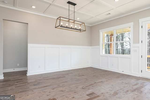 unfurnished room with coffered ceiling, a notable chandelier, and wood-type flooring