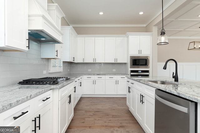 kitchen featuring light hardwood / wood-style flooring, tasteful backsplash, custom exhaust hood, sink, and appliances with stainless steel finishes