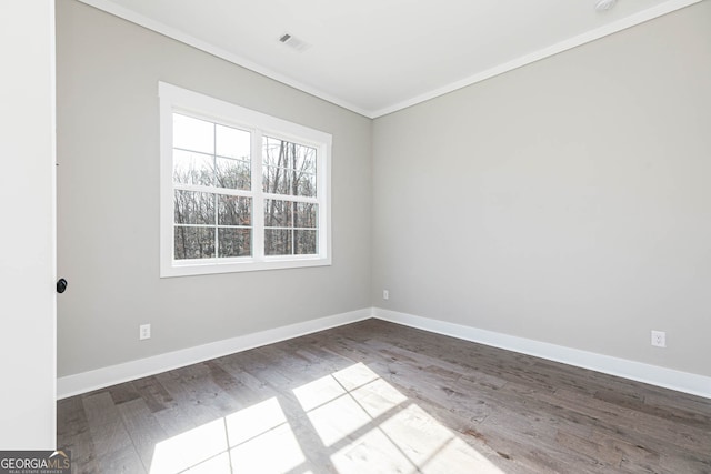 empty room featuring ornamental molding and dark hardwood / wood-style floors