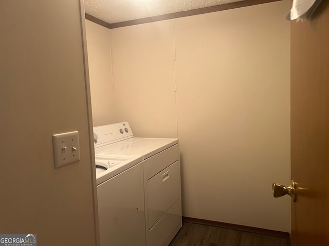 washroom with hardwood / wood-style flooring, a textured ceiling, and washing machine and dryer