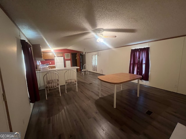 interior space with ceiling fan, vaulted ceiling, a textured ceiling, and hardwood / wood-style flooring