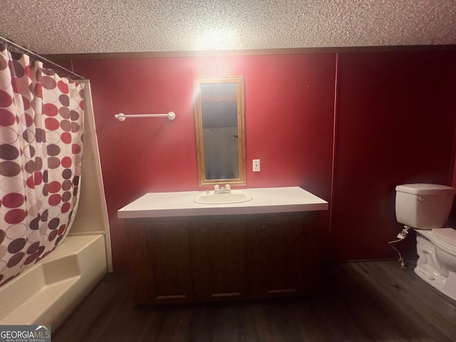 full bathroom with shower / bath combo, a textured ceiling, hardwood / wood-style flooring, toilet, and vanity