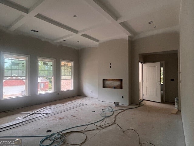 unfurnished living room featuring a fireplace, beam ceiling, and coffered ceiling