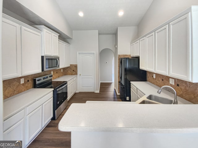 kitchen featuring appliances with stainless steel finishes, sink, backsplash, and dark wood-type flooring